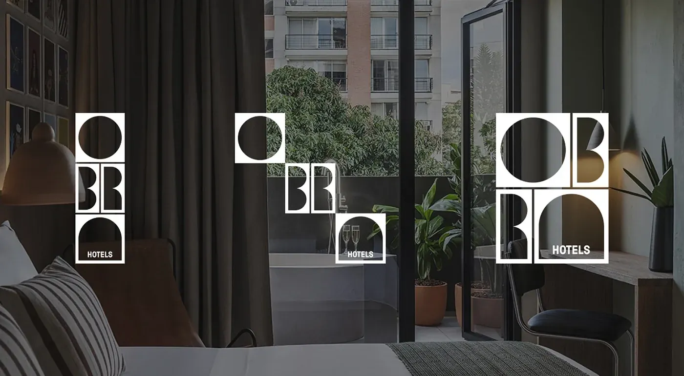 Logo Obra Hotels Medellín en habitación de hotel moderno con balcón y vistas a la ciudad.