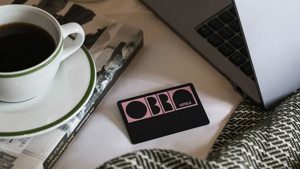Desayuno y laptop en cama de Obra Hotels Medellín.