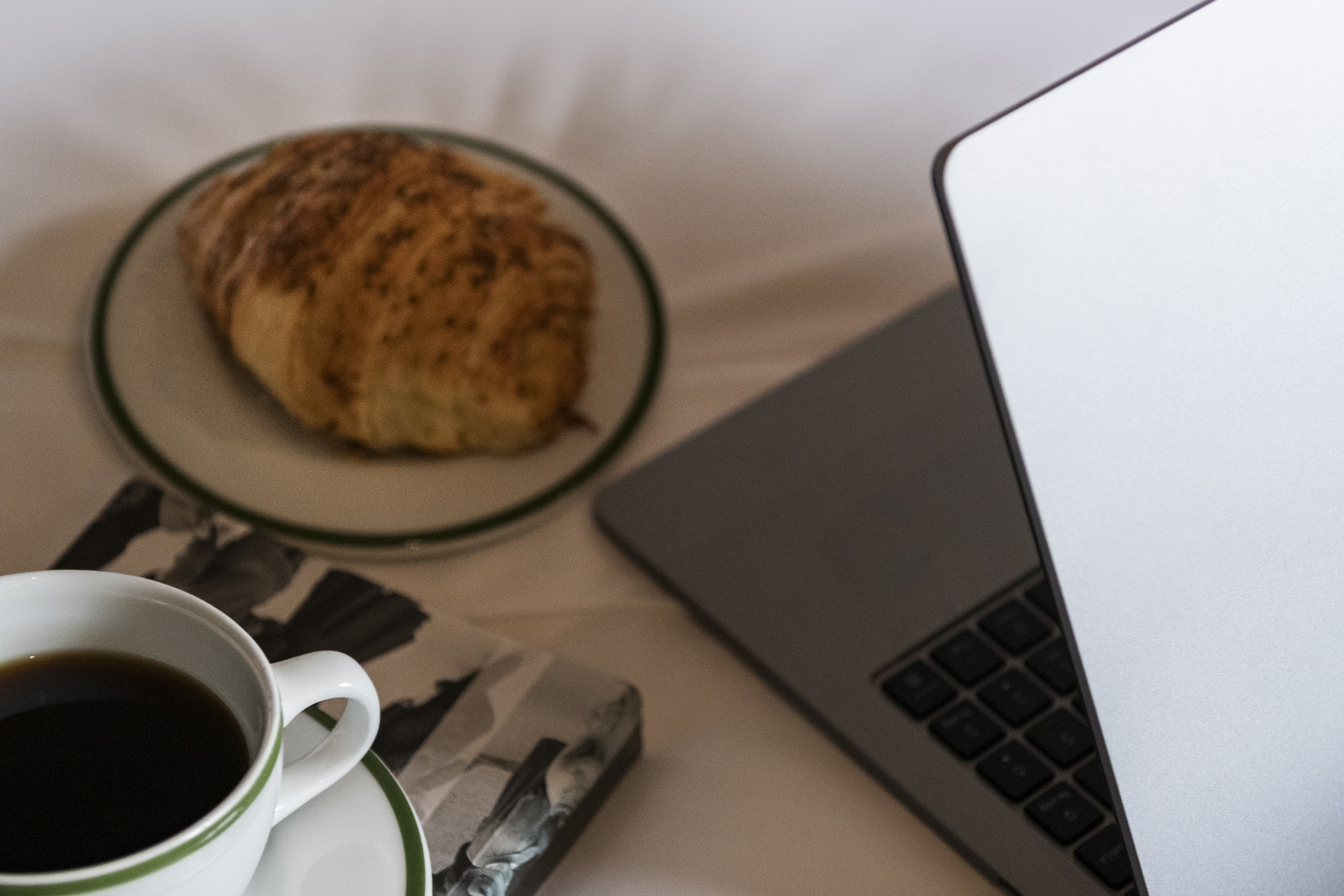 Desayuno con Obra Hotels Medellin y portátil en cama de hotel.