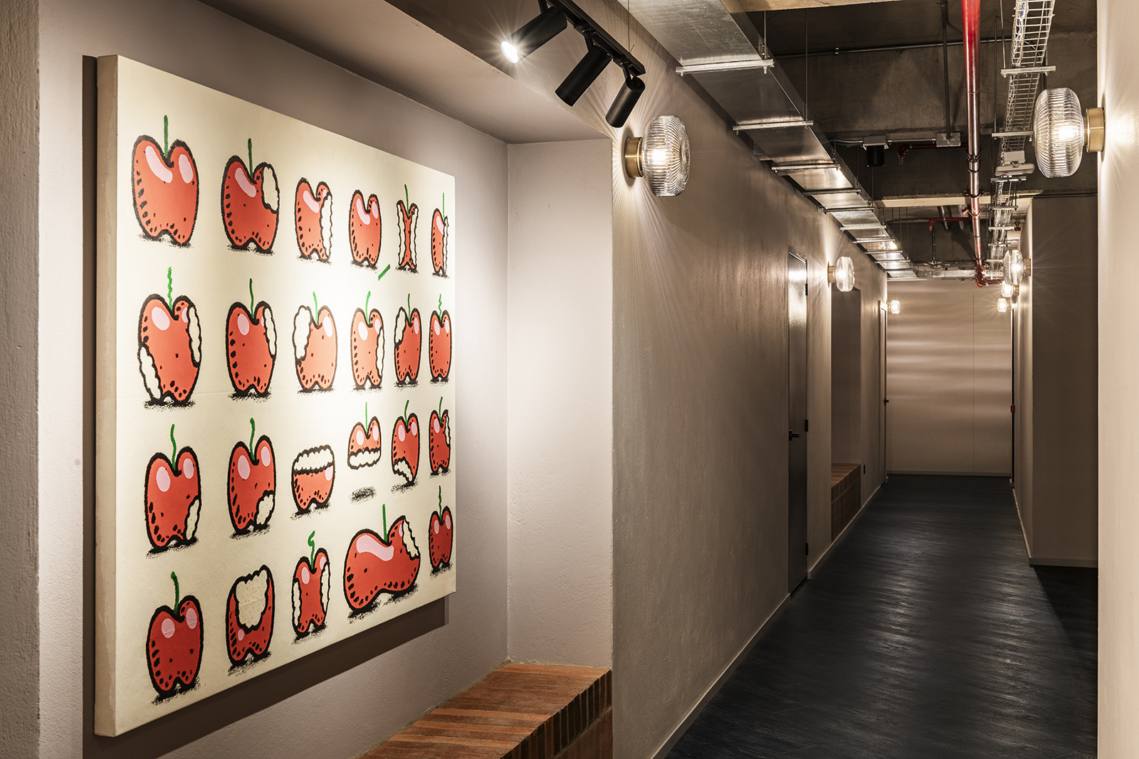 Decoración de pasillo de hotel con arte de manzanas y iluminación moderna Obra Hotels Medellin