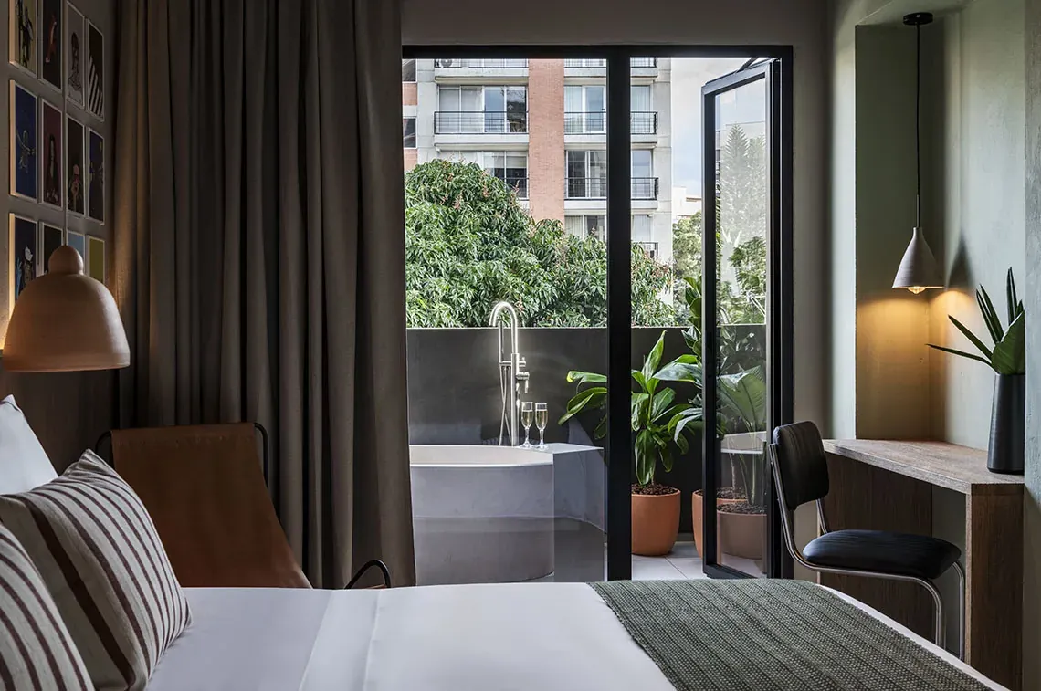 Stylish room with art at Obra Hotels Medellín, featuring a balcony with city views and breakfast.