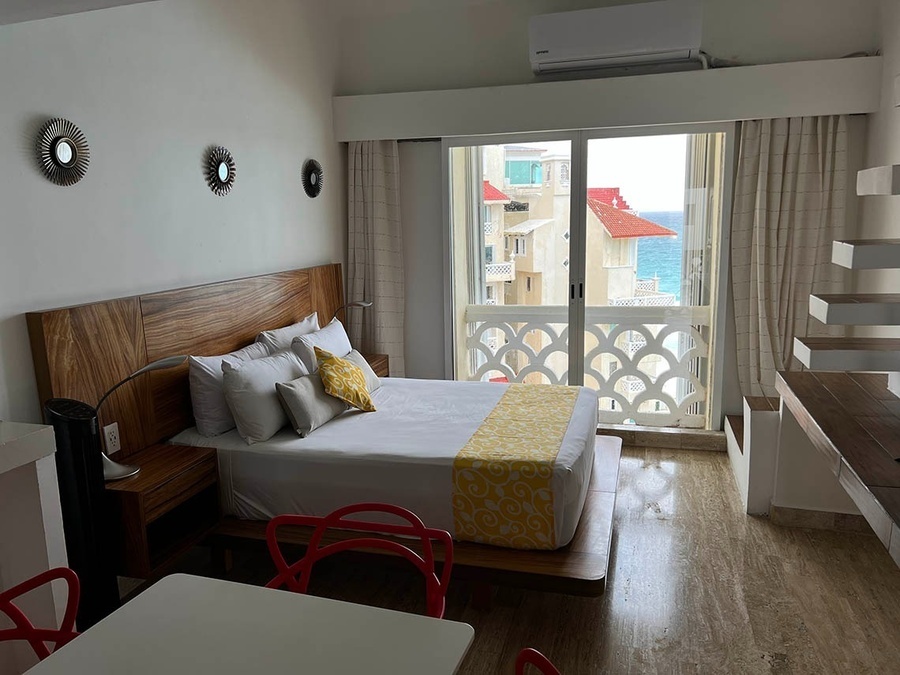 a hotel room with a king size bed and a view of the ocean