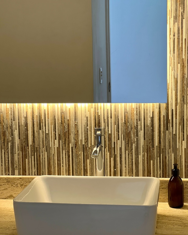 un lavabo y un espejo en un baño con baldosas de madera