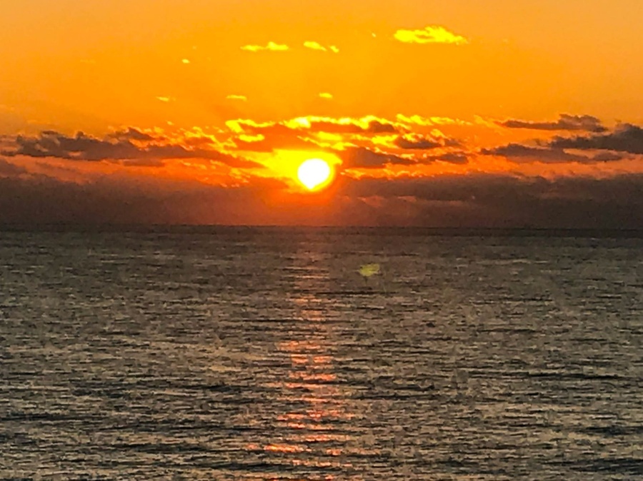 the sun is setting over a body of water