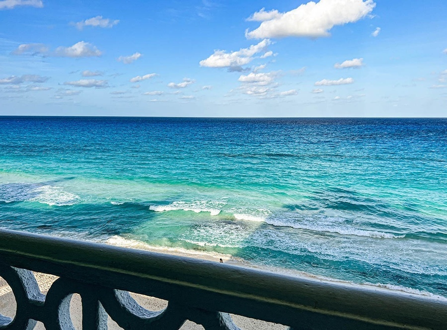 a view of the ocean from a balcony on a sunny day
