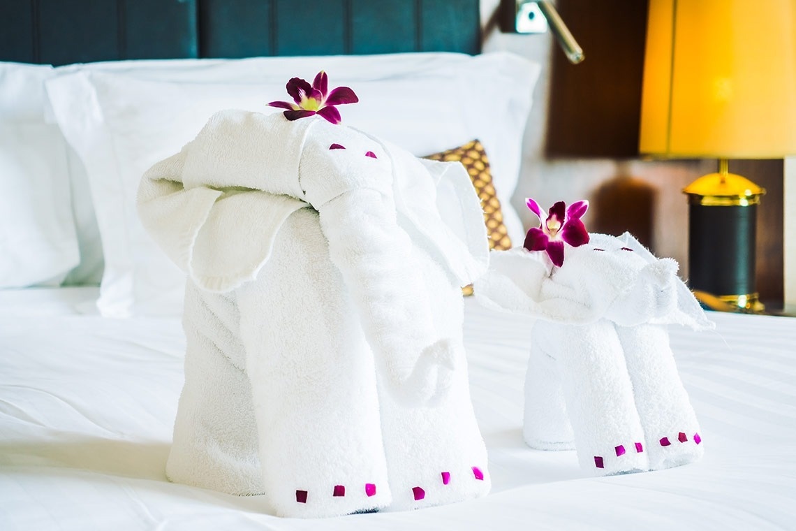 dos toallas en forma de elefante están sobre una cama