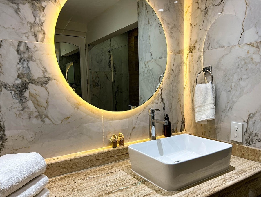 a bathroom with a sink and a round mirror