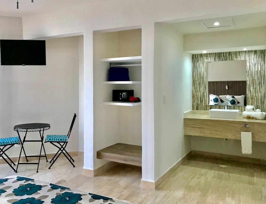 a hotel room with a table and chairs and a sink