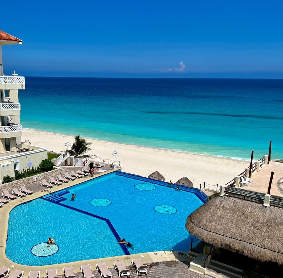 a large swimming pool in front of a beach