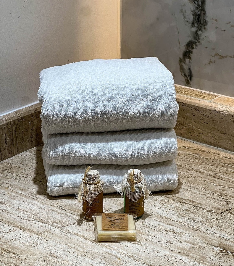 a stack of towels sits next to two bottles of soap