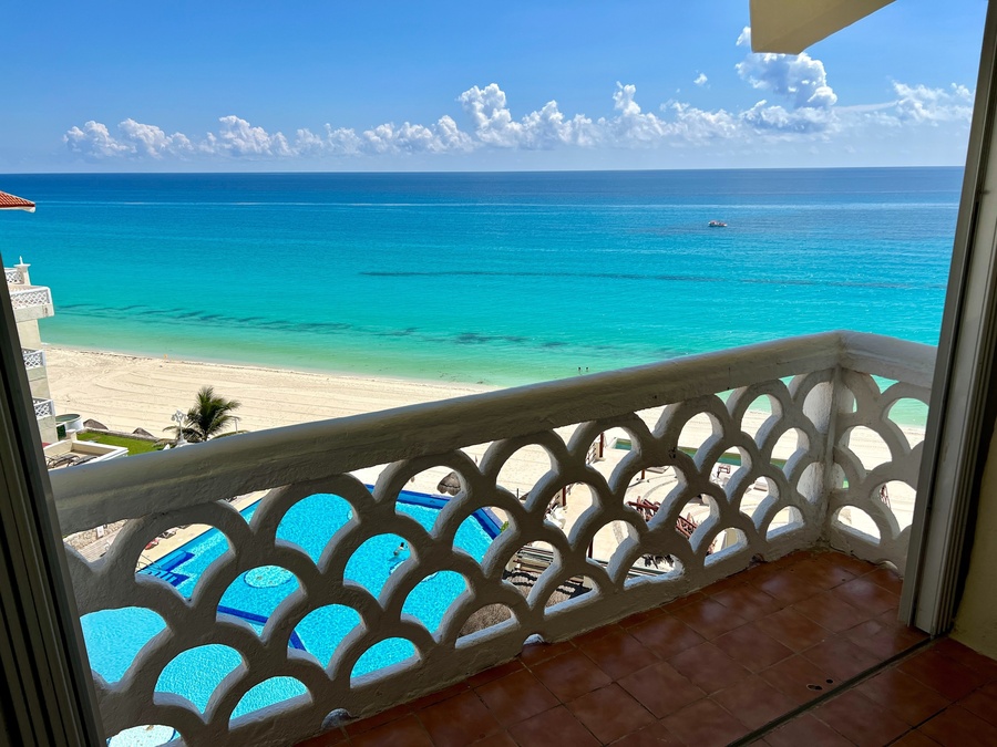 a view of the ocean from a balcony with a white railing