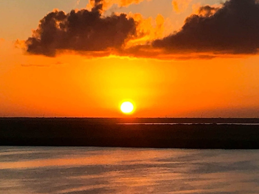 the sun is setting over a body of water