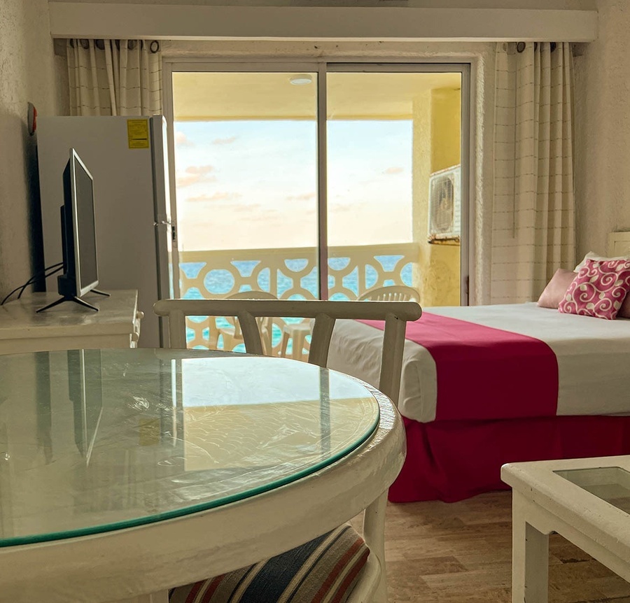 a hotel room with a sliding glass door leading to a balcony