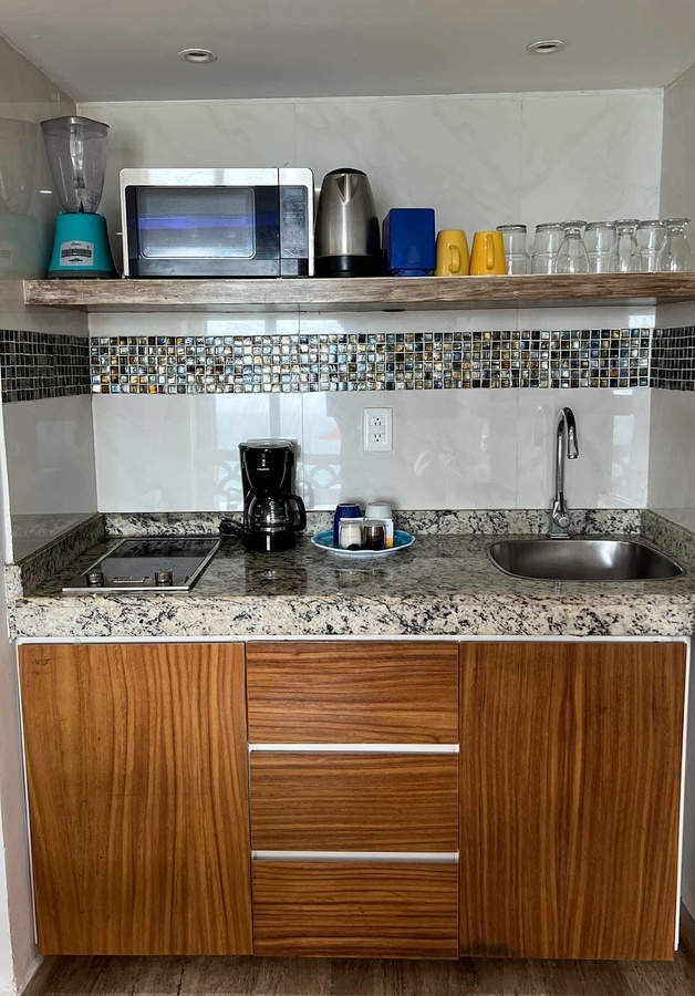 a kitchen with a blender a microwave and a sink