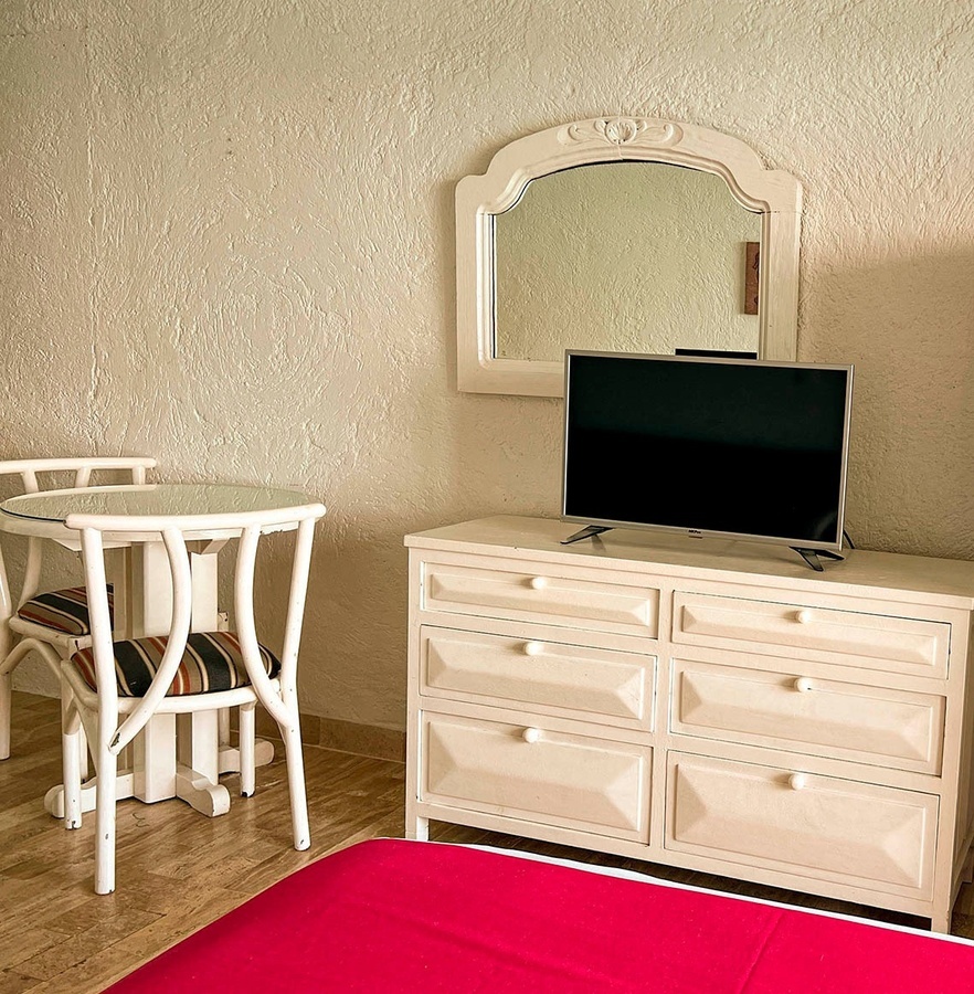 a white dresser with a flat screen tv on top of it
