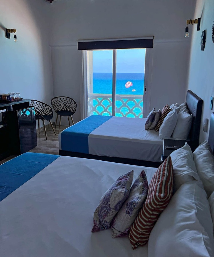 a hotel room with two beds and a view of the ocean