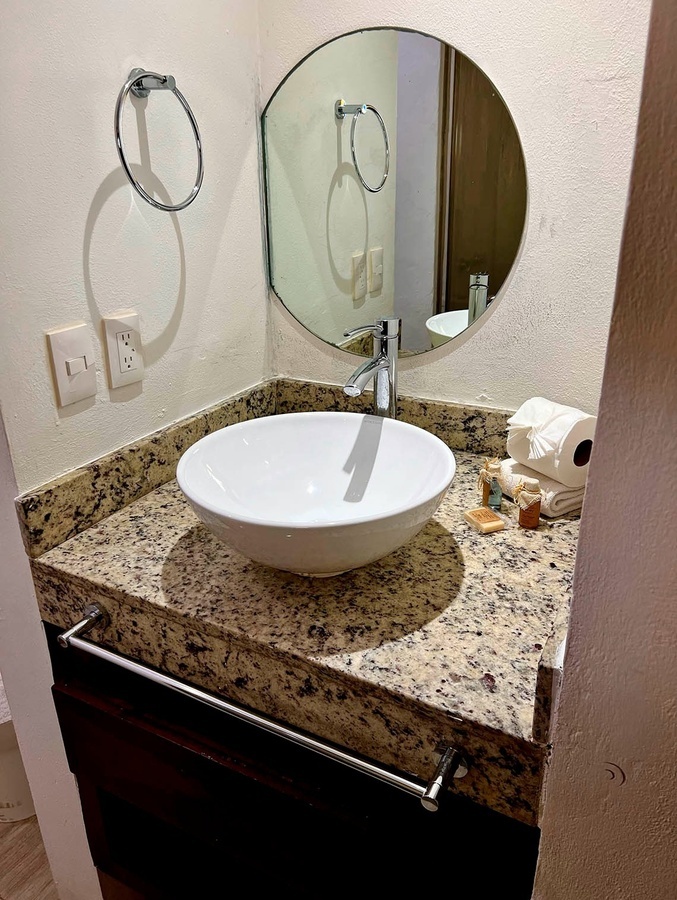 a bathroom with a sink and a round mirror