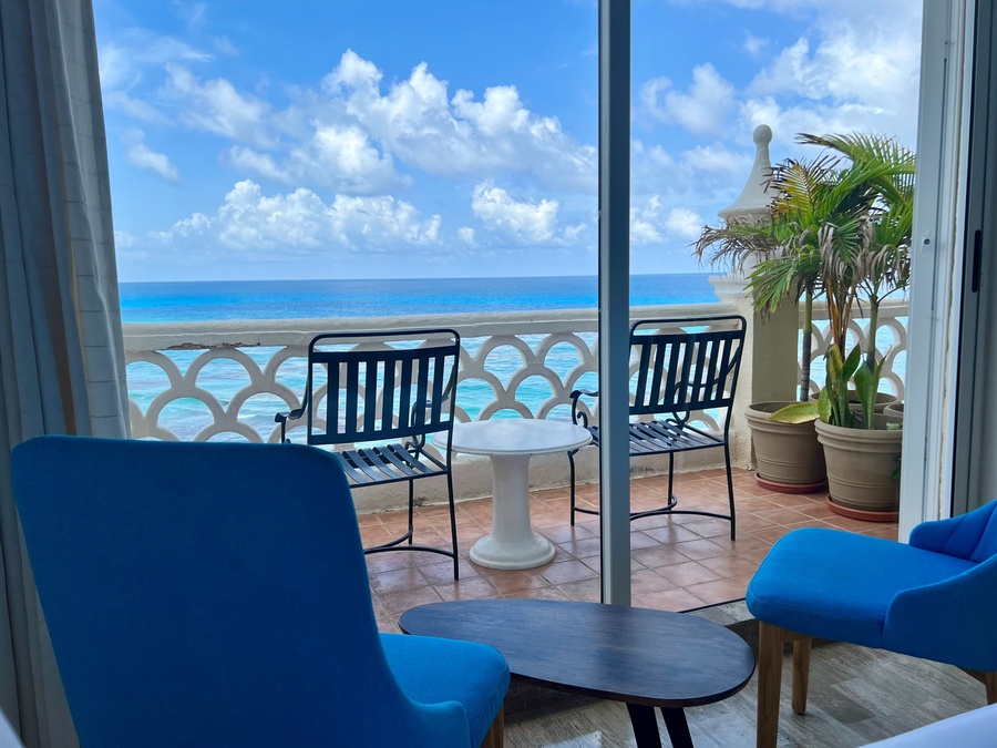 dos sillas y una mesa en un balcón con vistas al océano