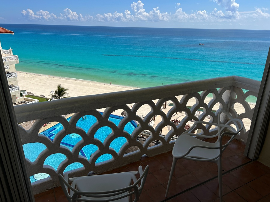 a balcony overlooking a swimming pool and the ocean