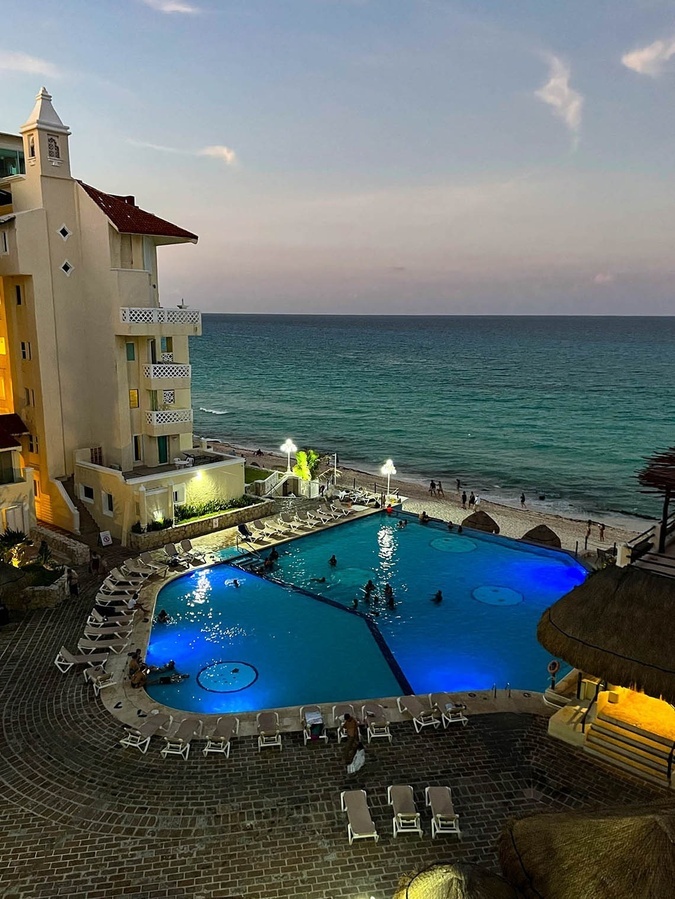 a large swimming pool in front of a building overlooking the ocean