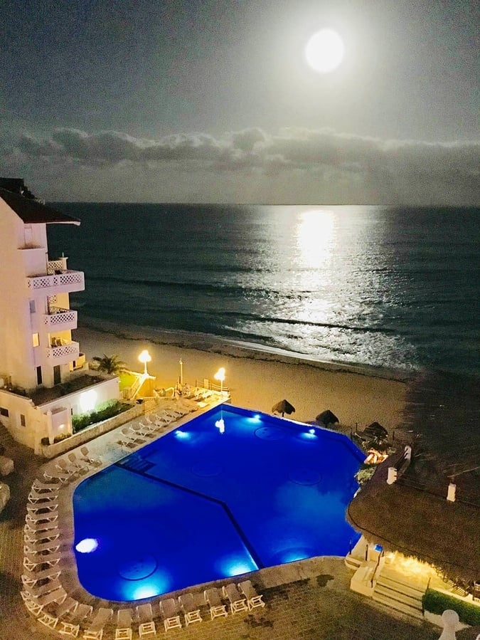 a full moon shines over a large swimming pool