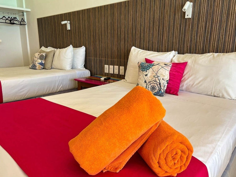 a hotel room with two beds and two towels on the bed