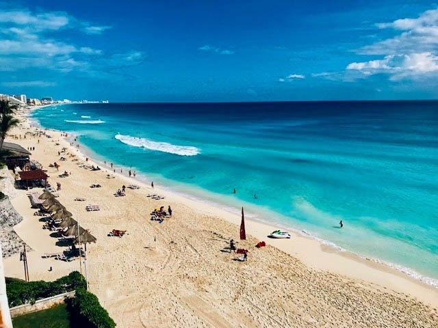 an aerial view of a beach with a jet ski in the water