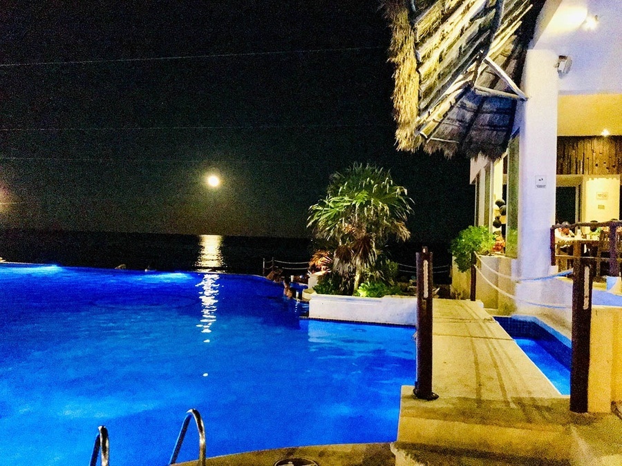 a large swimming pool is lit up at night