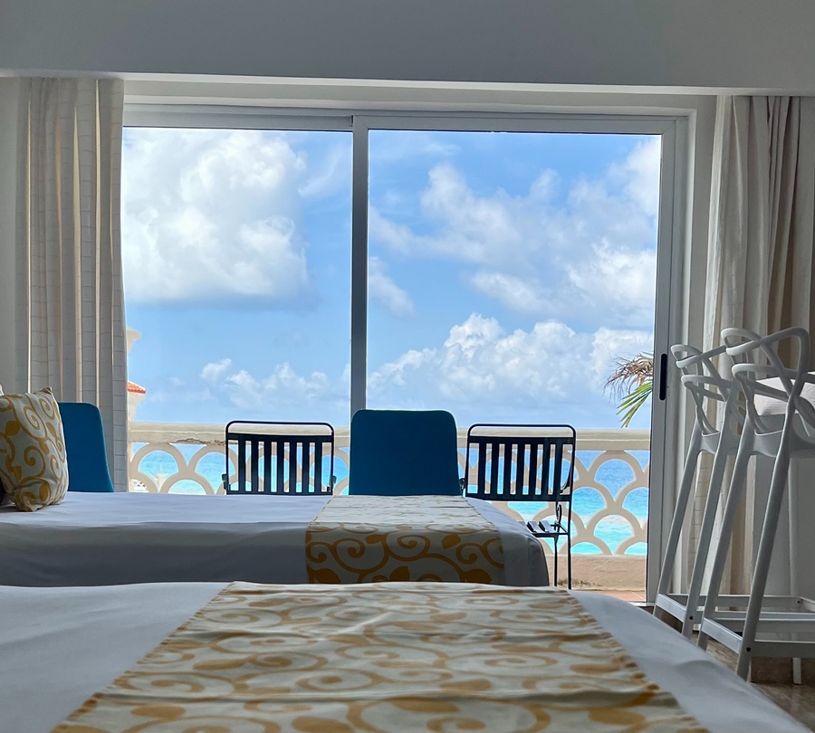 a hotel room with two beds and a view of the ocean