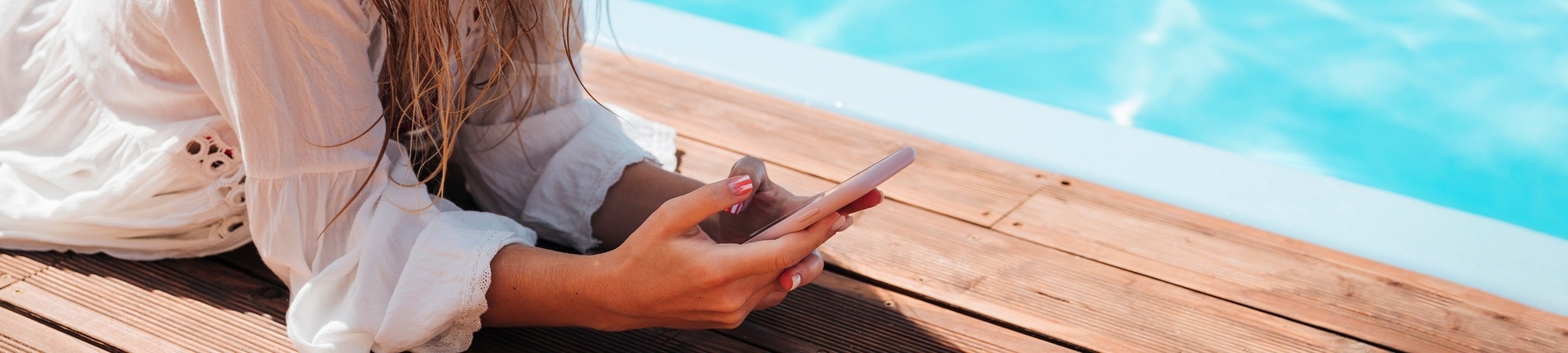 a woman laying on a wooden deck using a cell phone