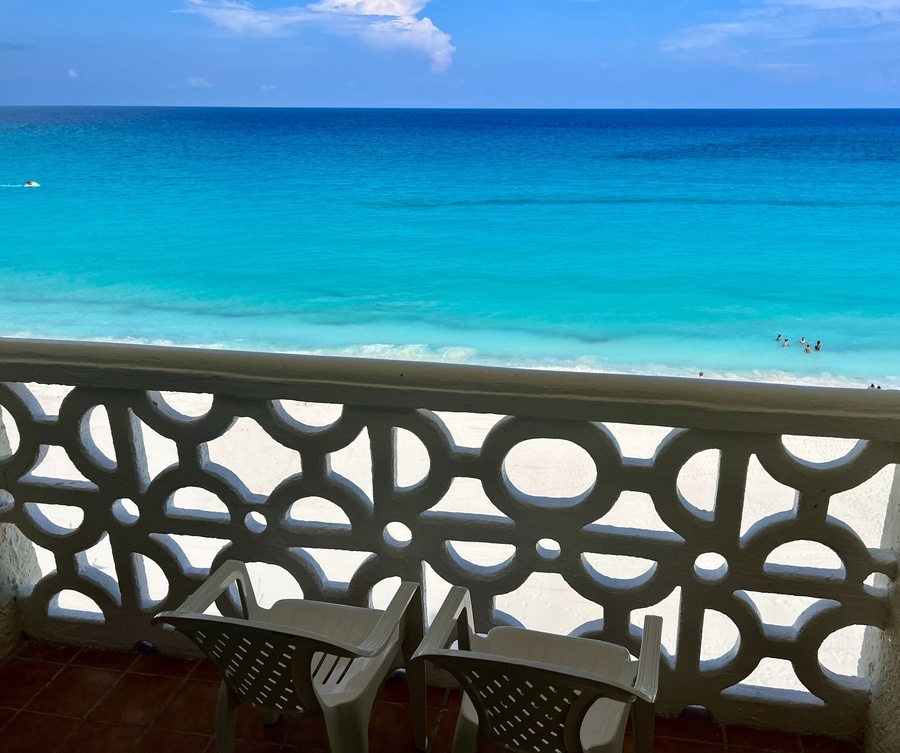 two chairs on a balcony overlooking the ocean