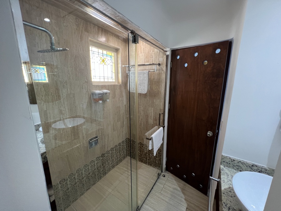 a bathroom with a walk in shower and a stained glass window