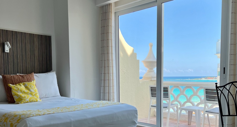 a hotel room with a bed and a view of the ocean