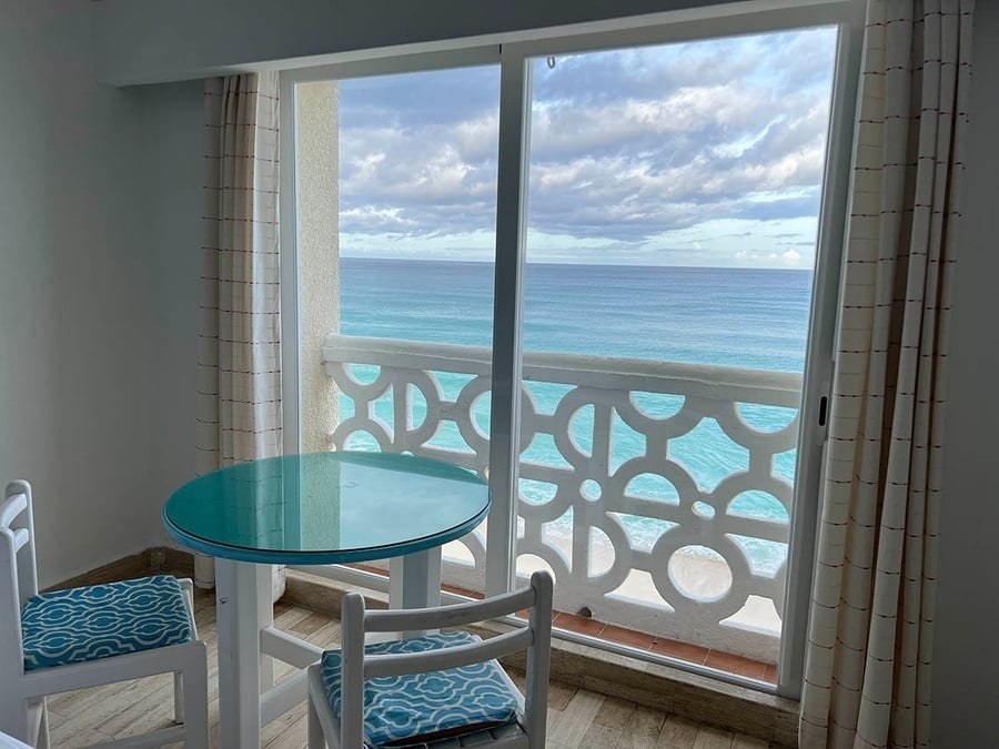 a room with a table and chairs and a view of the ocean