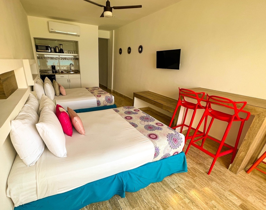 a hotel room with two beds and a small kitchen