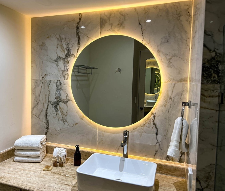 a bathroom with a round mirror and a sink