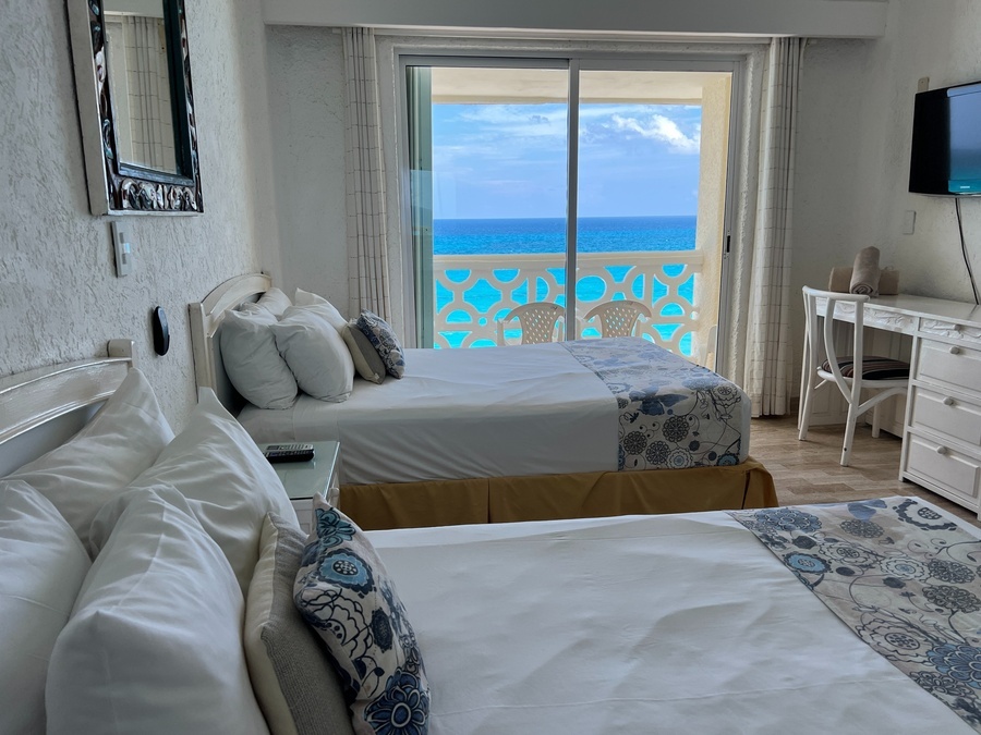 a hotel room with two beds and a flat screen tv