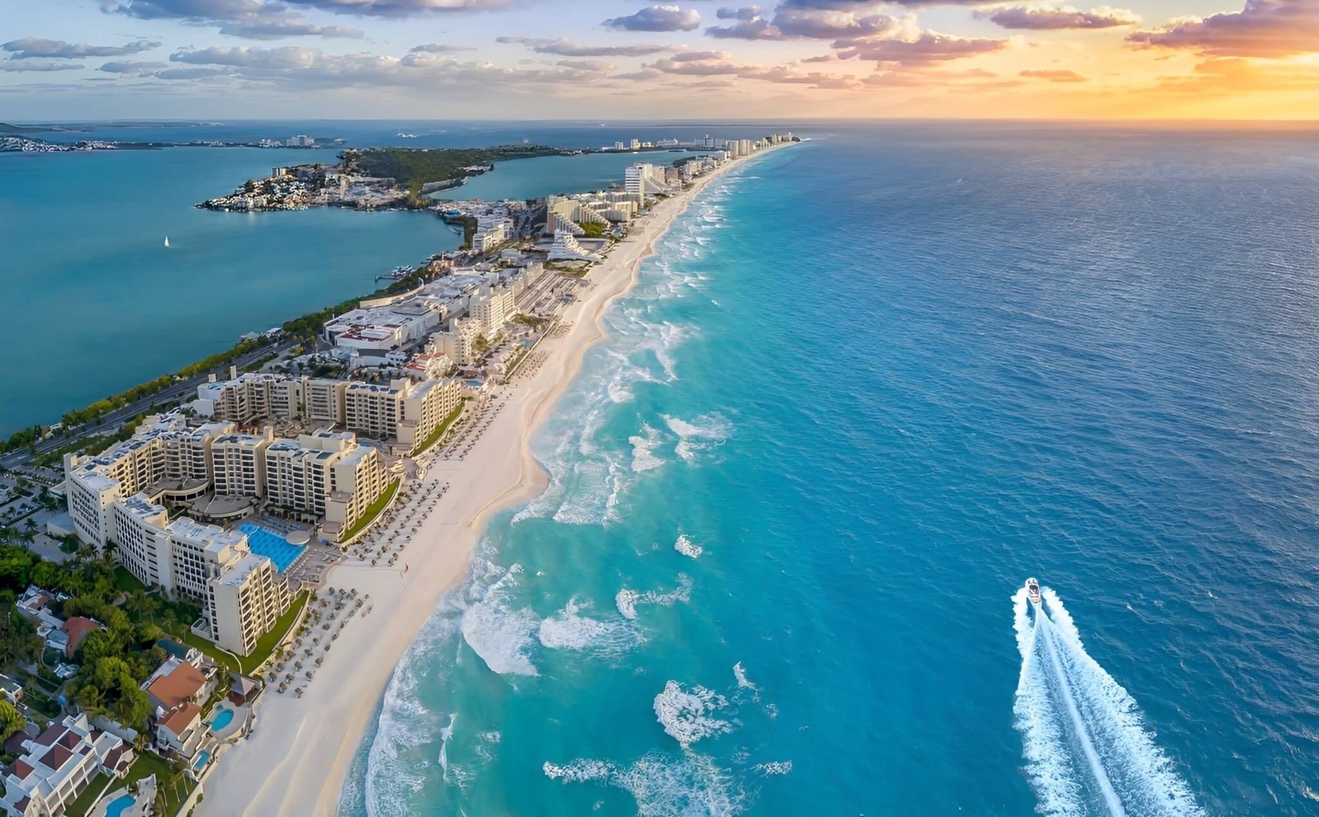 an aerial view of a beach with a boat in the water