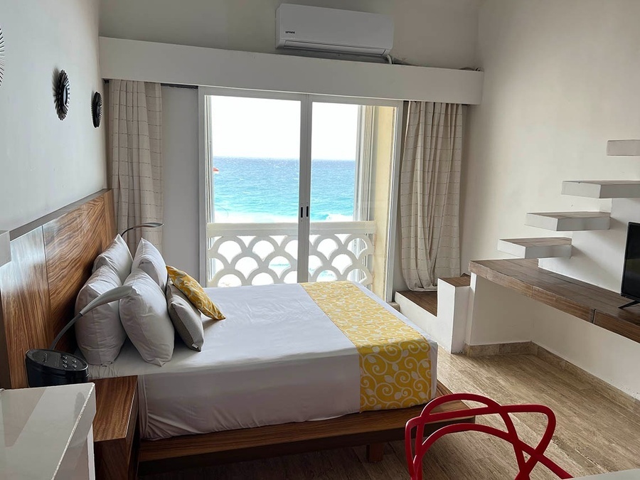 a hotel room with a king size bed and a view of the ocean