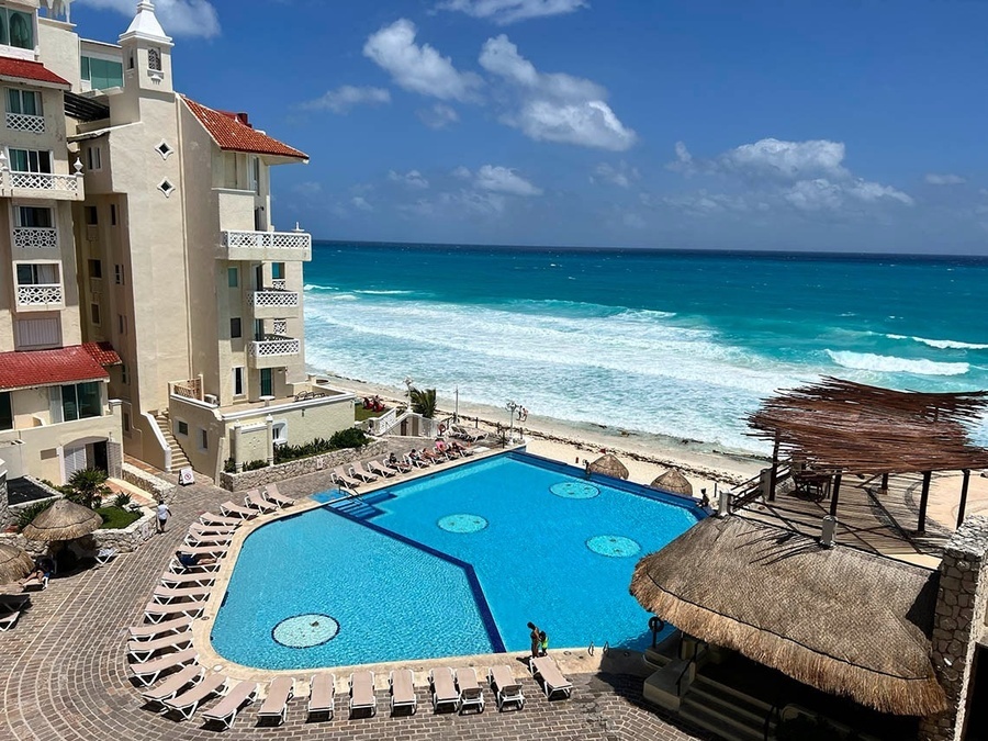 a large swimming pool is surrounded by chairs and umbrellas