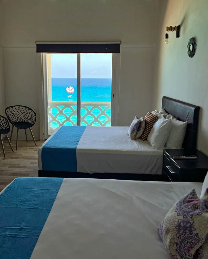a hotel room with two beds and a view of the ocean
