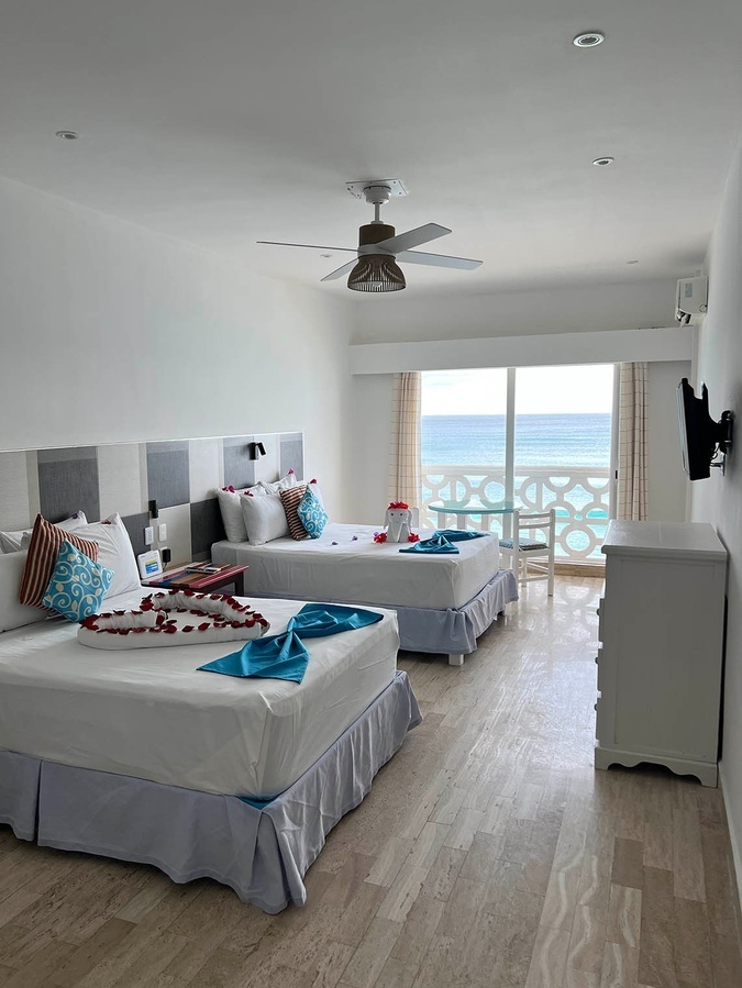 a hotel room with two beds and a ceiling fan