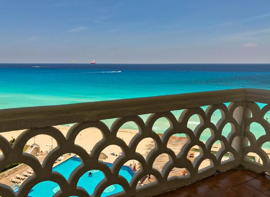 a balcony overlooking a swimming pool and the ocean