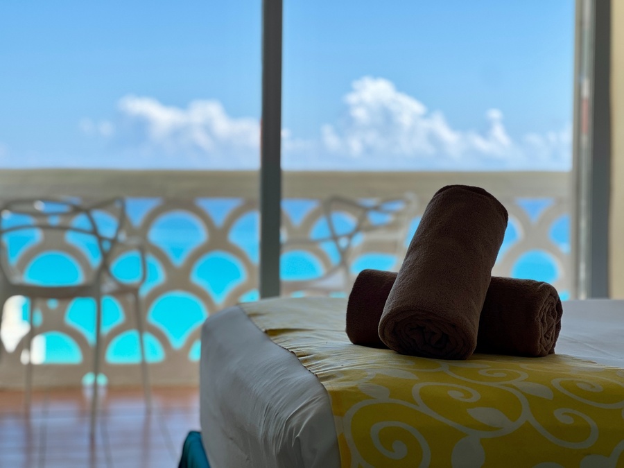 dos toallas están sobre una cama con una vista al océano