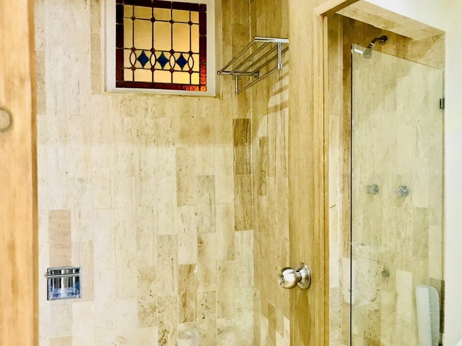 a shower with a stained glass window above it