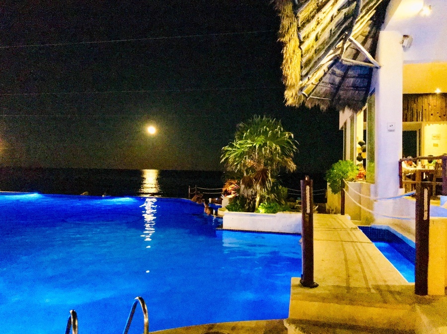 a swimming pool with a full moon in the background