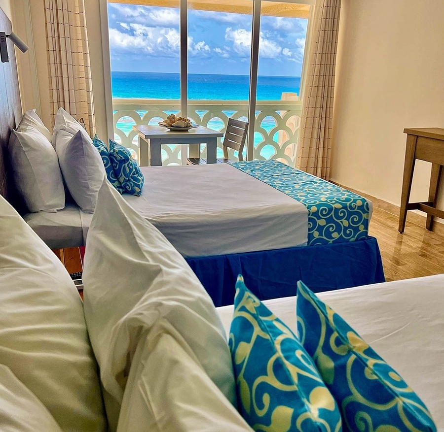 a hotel room with two beds and a view of the ocean