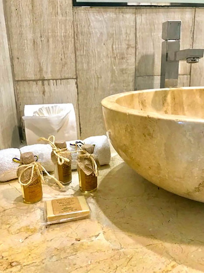 a bathroom counter with a sink and bottles of soap