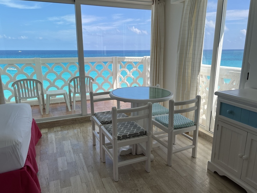 a room with a table and chairs with a view of the ocean