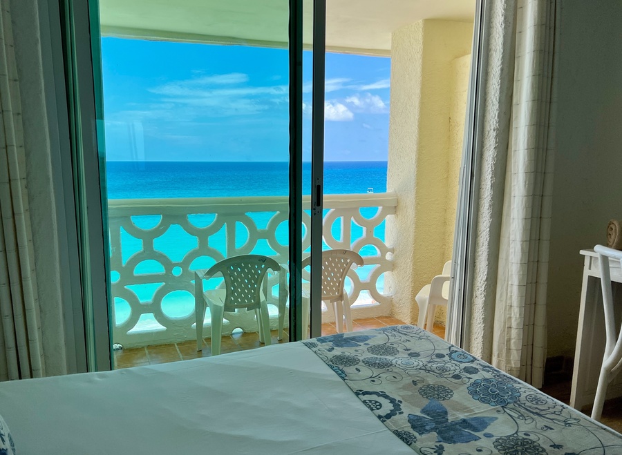 a hotel room with a balcony overlooking the ocean